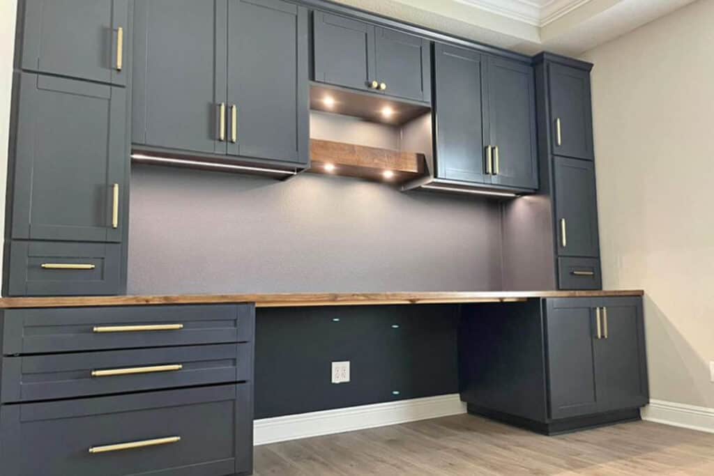 Dark gray kitchen cabinets with wood accents and under-cabinet lighting, designed for a modern, functional workspace in North Port, FL.